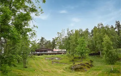 a house in the middle of a field with trees at 3 Bedroom Stunning Home In Vossestrand in Vossestrand