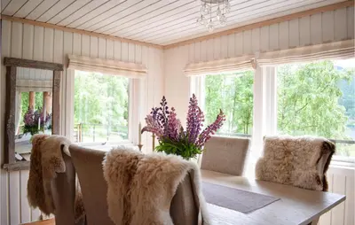 a dining room with a table and chairs and windows at 3 Bedroom Stunning Home In Vossestrand in Vossestrand