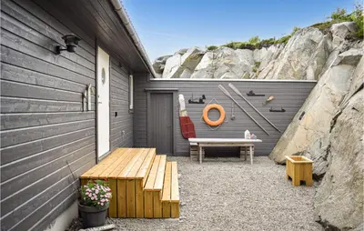 a patio with a bench next to a wall at Nice Home In Sveio With House Sea View in Sveio