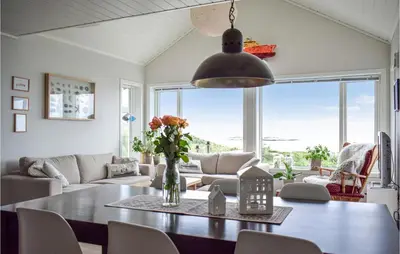 a living room with a table and a couch at Nice Home In Sveio With House Sea View in Sveio