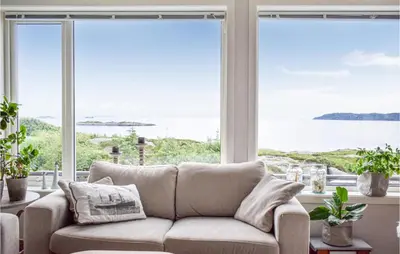 a living room with a couch in front of a window at Nice Home In Sveio With House Sea View in Sveio