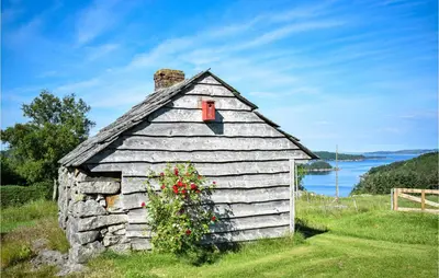 an old house with a red window and flowers at Awesome Home In Fitjar With Wifi in Fitjar