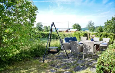 a patio with a table and chairs and a fire pit at Awesome Home In Fitjar With Wifi in Fitjar