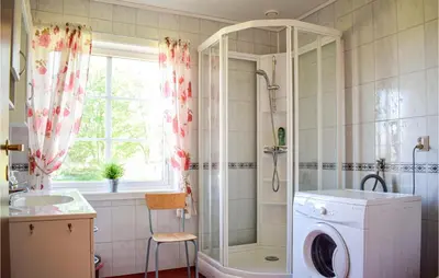 a bathroom with a shower and a washing machine at Awesome Home In Fitjar With Wifi in Fitjar