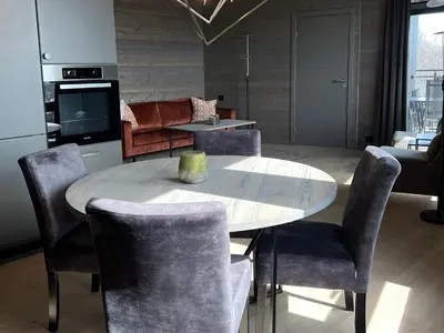 a kitchen with a table and chairs and a living room at Riddertunets moderne in Beitostøl