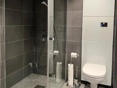 a bathroom with a glass shower with a toilet at Riddertunets moderne in Beitostøl