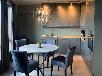a kitchen with a table with chairs and a sink at Riddertunets moderne in Beitostøl