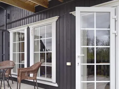 a house with white doors and chairs on a patio at 5 person holiday home in Rauland-By Traum in Rauland