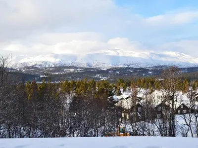 a view of snow covered mountains with houses and trees at 5 person holiday home in Rauland-By Traum in Rauland