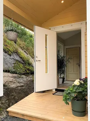 a front door of a house with flowers on a porch at Nesje Gardstun in Oppstryn