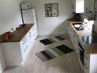 a kitchen with white cabinets and a white refrigerator at 6 person holiday home in Halsanaustan-By Traum in Korsnes