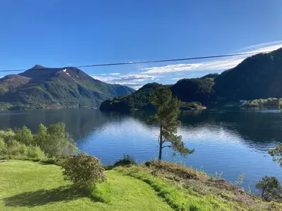 a lake with a tree and mountains in the background at 6 person holiday home in Halsanaustan-By Traum in Korsnes