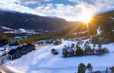 a ski resort with the sun shining on the snow at Mountain retreat in Uvdal WIFI SAUNA in Uvdal
