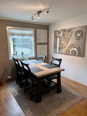 a dining room table with chairs and a painting on the wall at Mountain retreat in Uvdal WIFI SAUNA in Uvdal