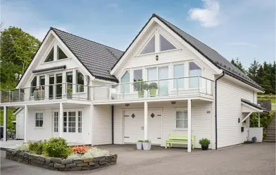 a white house with a porch and a bench at 4 Bedroom Gorgeous Home In Herdla in Herlø