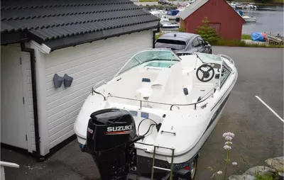 a white boat is parked next to a building at 4 Bedroom Gorgeous Home In Herdla in Herlø