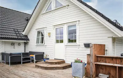 a white house with a deck and a patio at 4 Bedroom Gorgeous Home In Herdla in Herlø