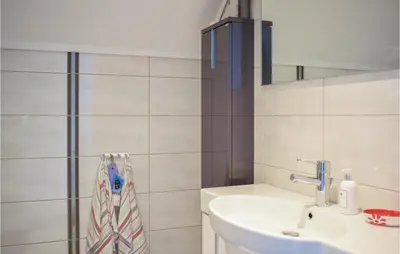 a bathroom with a sink and a mirror at 4 Bedroom Gorgeous Home In Herdla in Herlø