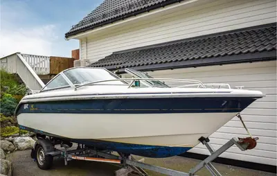 a boat is parked in front of a house at 4 Bedroom Gorgeous Home In Herdla in Herlø