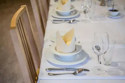 a long table with plates and glasses and a hat on it at Gaupnetunet Hotell og Hytter in Gaupne