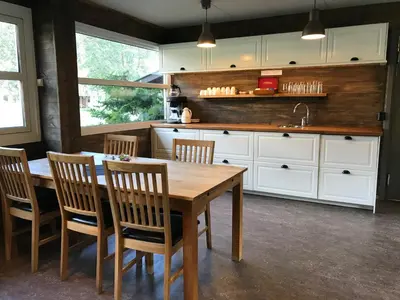 a kitchen with a wooden table and chairs and a sink at Gaupnetunet Hotell og Hytter in Gaupne