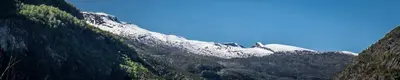 a snow covered mountain in the middle of a valley at Gaupnetunet Hotell og Hytter in Gaupne