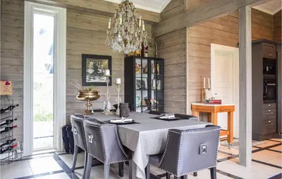 a dining room with a table and chairs and a chandelier at Lovely Home In Vossestrand With Wifi in Vossestrand