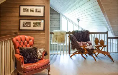 a living room with two chairs and a balcony at Lovely Home In Vossestrand With Wifi in Vossestrand