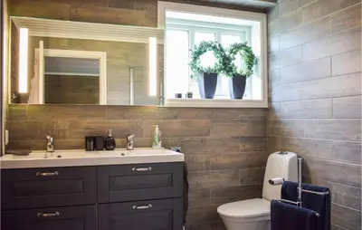 a bathroom with a sink and a toilet and a mirror at Lovely Home In Vossestrand With Wifi in Vossestrand