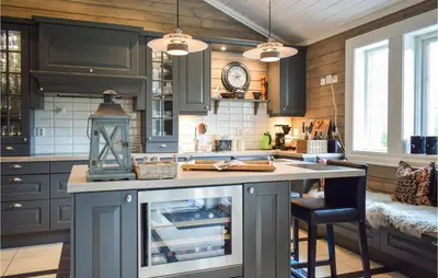 a kitchen with blue cabinets and a counter with a clock on the wall at Lovely Home In Vossestrand With Wifi in Vossestrand