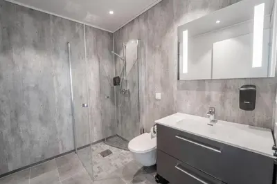 a bathroom with a toilet and a sink and a shower at Runde Panorama - Ørneredet in Runde