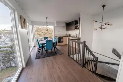 a kitchen and dining room with a table and chairs at Runde Panorama - Ørneredet in Runde