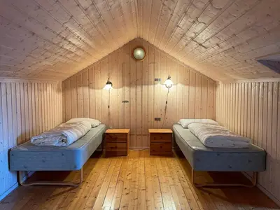 a room with two beds in a wooden wall at Tyinkrysset panorama in Tyinkrysset
