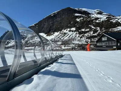 a snow covered road in front of a mountain at Tyinkrysset panorama in Tyinkrysset