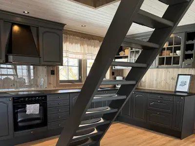 a kitchen with black cabinets and a spiral staircase at Tyinkrysset panorama in Tyinkrysset