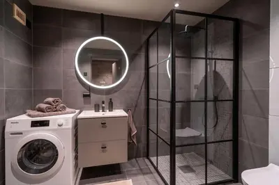 a bathroom with a washing machine and a mirror at Riddertunets luksuriøse in Beitostøl