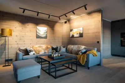 a living room with a couch and a table at Riddertunets luksuriøse in Beitostøl