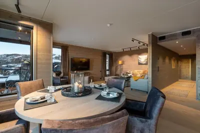 a dining room with a table and chairs at Riddertunets luksuriøse in Beitostøl