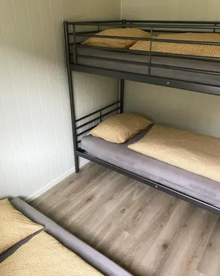 two bunk beds in a room with wooden floors at Hillegård in Lærdalsøyri
