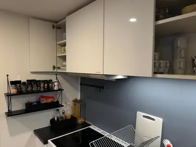 a kitchen with white cabinets and a sink at Great place with a stunning view of the mountains and the fjord in Ålesund