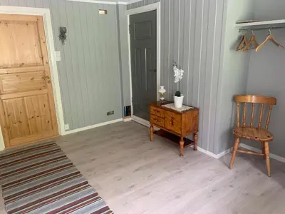 a hallway with a chair and a table and a door at Engen Gård in Innfjorden