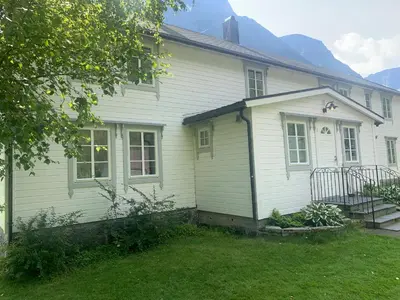 a white house with a yard in front of it at Engen Gård in Innfjorden