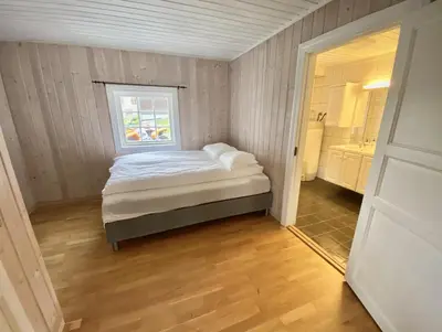 a small bedroom with a bed and a window at Stryn - Faleide -hytte med fjord og fjell utsikt in Stryn