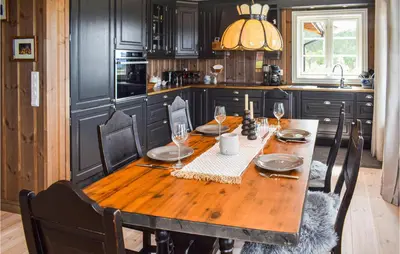 a kitchen with a wooden table with wine glasses at Lovely Home In Tuddal With Jacuzzi in Tuddal
