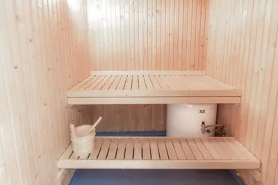 a sauna with a wooden shelf and a bucket in it at Fagertoppen 12B in Trysil