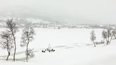 a snow covered field with trees in the foreground at Lake View Apartment 4 bedrooms and 2 bathrooms in Sykkylven
