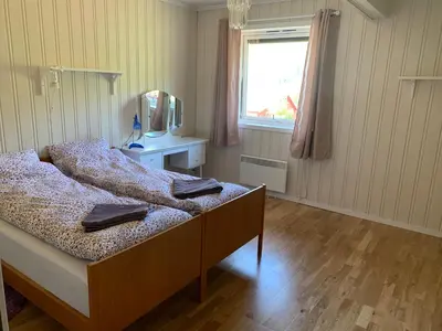 a bedroom with a bed with a dresser and a mirror at Feriehus med utsikt til fjord og fjell in Gvammen