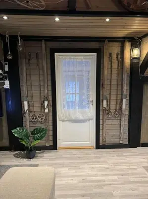 a door with a window and a plant in a room at Eidsviklaaven in Ålesund