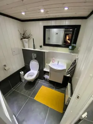 a bathroom with a toilet and a sink and a mirror at Eidsviklaaven in Ålesund