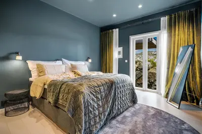 a bedroom with a bed with blue walls and a window at 